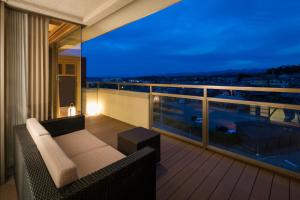 加贺优诺库尼田思友酒店的阳台配有沙发,享有城市景观。