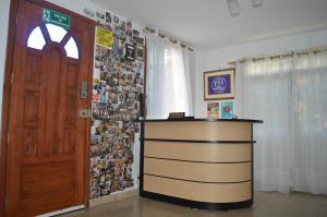 瓜亚基尔Casa Michael的一间设有书桌的房间、一扇门和一堵带照片的墙壁