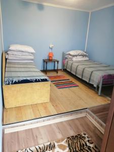 PaduyelisŽalioji的客房设有两张床,铺有木地板。