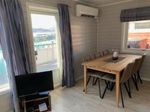 Sjøvegan贾斯尼布里格度假屋的一间带桌子和电视的用餐室