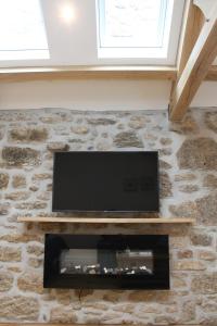 PaulBryher Cottage的石墙上的平面电视