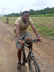 莫罗戈罗Mikumi Faru Tented Camp的骑着自行车在土路的人