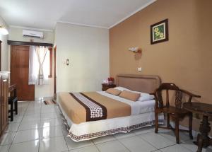 日惹Hotel Mataram Malioboro的一间卧室配有一张床和一张桌子