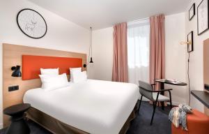 帕讷Hôtel ibis Styles Montargis Arboria的酒店客房设有一张大床和一张书桌。