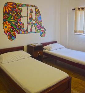 科伦坡City Beds Colombo的一间设有两张床的客房,墙上挂着一幅画