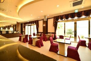 马公传承堡大饭店的餐厅设有红色的椅子和桌子以及窗户。
