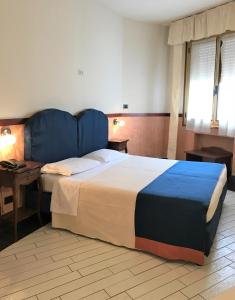 博洛尼亚圣费利切酒店的一间卧室配有一张大床和蓝色床头板