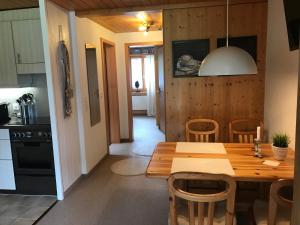 茨韦西门Ferienwohnung Résidence Sonnegg - Hein的厨房以及带木桌和椅子的用餐室。