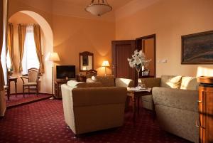 乌赫尔堡施朗斯酒店的客厅配有沙发和鲜花桌
