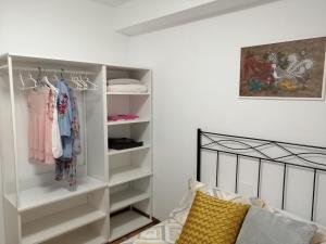 希洪Apartamento Quety Gijón的卧室配有带衣服的白色衣柜