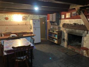 巴拉德瓦利扎斯Lambae的厨房配有壁炉、桌子和冰箱。