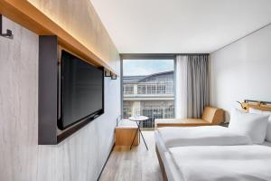 莱比锡H2 Hotel Leipzig的酒店客房设有两张床和一台平面电视。