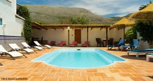 佩里那Casa La Negra的一个带桌椅的游泳池和一个庭院