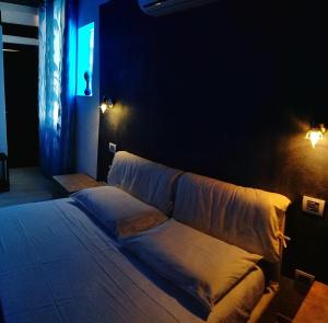 夸尔图-圣埃莱娜Antico Centro Quartu B&B的一张位于带沙发的黑暗客房内的床铺