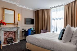 阿姆斯特丹De Ware Jacob Boutique Hotel的酒店客房配有一张床和一个壁炉。