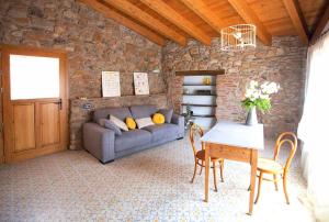ArsèguelEl Mas de Sant Vicenç - apartamentos rurales的客厅配有沙发和桌椅
