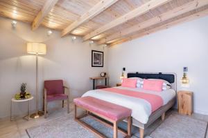 干尼亚Viaggio Elegant Rooms的一间卧室配有一张大床和一把椅子
