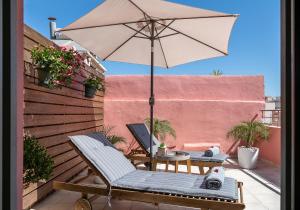 干尼亚Viaggio Elegant Rooms的庭院配有遮阳伞和桌椅。