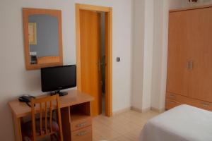 厄尔·阿尔特梅塞格尔旅馆的一间卧室配有一张桌子、一台电视和一张床
