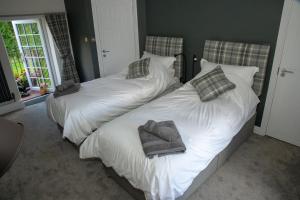 普雷斯顿Alpaca Fold的卧室内的两张床和毛巾
