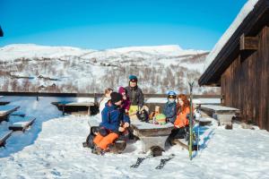 VågsliHaukelifjell Skisenter的一群坐在雪地桌子上的人