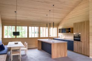 埃格Fuchsegg Eco Lodge的一间带木墙和桌子的厨房以及一间用餐室