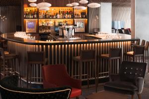 鲁瓦西昂法兰西巴黎戴高乐机场及会议中心美居酒店的餐厅内的酒吧配有椅子和柜台