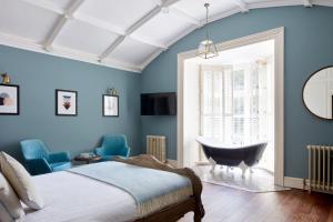 纽波特小修道院酒店的一间卧室配有一张床和一个窗户内的浴缸