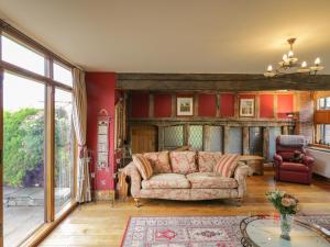 阿伯加文尼Pentre Barn的带沙发和红色墙壁的客厅