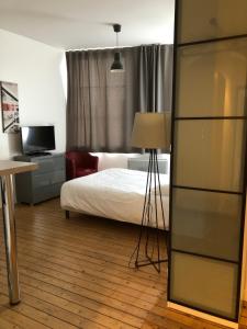佩罗讷索姆旅馆的一间卧室配有一张床和一张带台灯的书桌