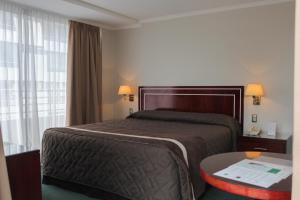 圣地亚哥莱昂纳多达芬奇酒店的酒店客房设有床、桌子和窗户。