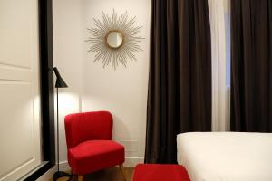 巴利亚多利德Hotel Colón Plaza的一间卧室配有红色椅子和镜子