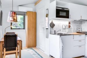 马尔默Cosy stay in southern Malmo的厨房配有白色橱柜、水槽和桌子