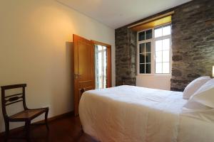 莫尼兹港Quinta do Serrado的卧室配有床、椅子和窗户。