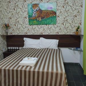 库亚巴Suíte 1, aconchegante, privativa e independente的一张床上,房间里有一幅豹子画