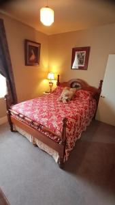 德洛兰Blakes Manor Self Contained Heritage Accommodation的一间卧室配有一张大床和红色的床罩