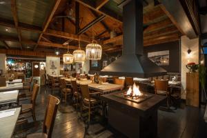 迪森Hotel & Restaurant - Auberge De Hilver的餐厅设有木制天花板和桌椅