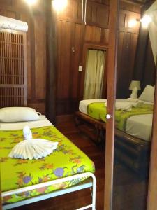 奈扬海滩Sea Pines & Liberg的一间卧室配有两张床和镜子
