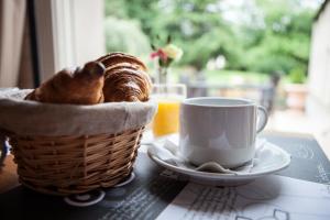 欧赖Hotel Le Branhoc - Brit Hotel Auray的桌上一篮面包和一杯咖啡