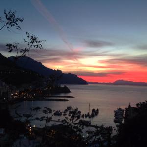 阿马尔菲Amalfi Resort的日落在水体上,与城市