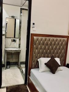 瓦拉纳西斯里象头神宫住宿加早餐旅馆的一间卧室配有一张带镜子的床,旁边是镜子
