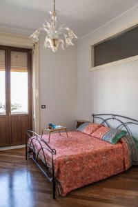 锡拉库扎Spa sul tempio d'apollo的一间卧室配有一张床和一个吊灯