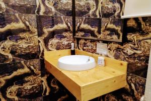 长滩岛Monallan Boracay Hotel的墙上设有木制水槽的浴室