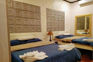 长滩岛Monallan Boracay Hotel的一间卧室配有两张床和镜子