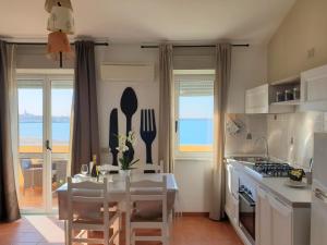 阿尔盖罗Appartamenti Sole 1的享有海景,设有带桌椅的厨房