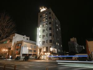 延冈市诺贝卡地区酒店 的一座高大的建筑,晚上有钟楼