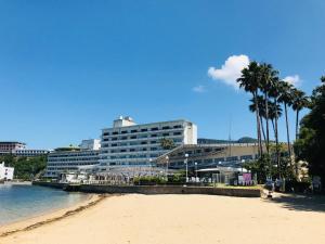 土庄町小豆岛国际酒店的棕榈树海滩和大型建筑