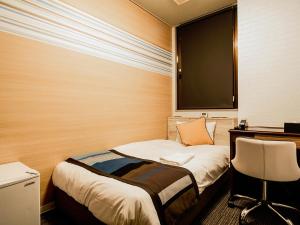 延冈市诺贝卡地区酒店 的客房设有两张床、一张桌子和一把椅子。