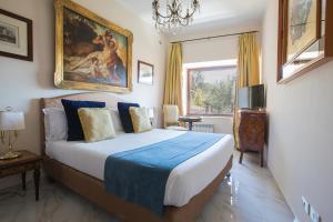 罗马Il Monastero Collection的卧室配有一张床,墙上挂有绘画作品