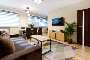 克拉科夫Hotel CONRAD Comfort的客厅配有沙发和桌子